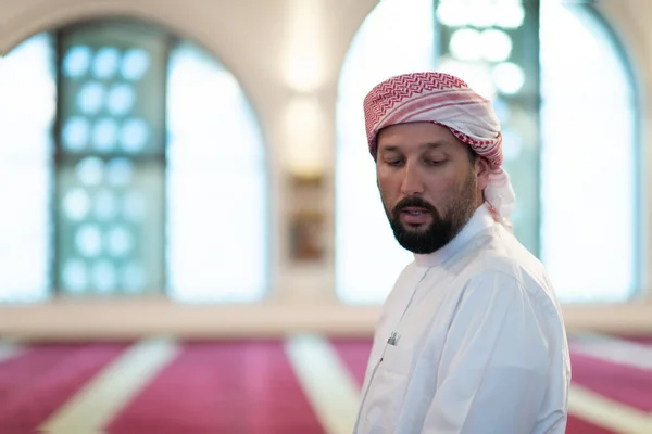 Un musulmán termina una oración girando la cabeza hacia un lado,. —  Fotos de Stock