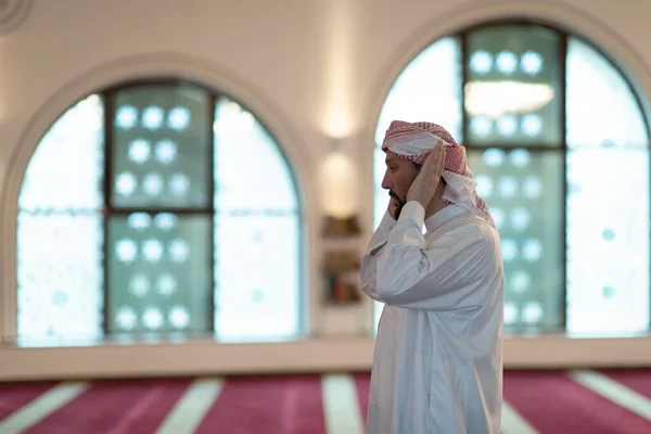 Um muçulmano começa a oferecer oração levantando as mãos no ar, um estado calmo em oração. — Fotografia de Stock