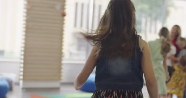 Bir grup küçük okul çocuğuyla el oyunları oynayan mutlu bir bayan öğretmen. Yüksek kalite 4k görüntü