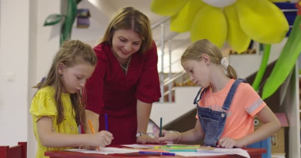 在日托中心的艺术课或小学课堂上与女教师一起画画时 有创意的孩子 慢动作高质量的4K镜头 — 图库视频影像