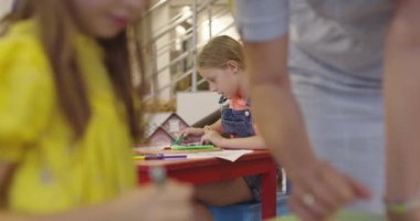 Bir kreşteki sanat dersinde yaratıcı çocuklar ya da ilkokul sınıfında bayan öğretmenle resim çizen çocuklar. Ağır çekim. Yüksek kalite 4k görüntü