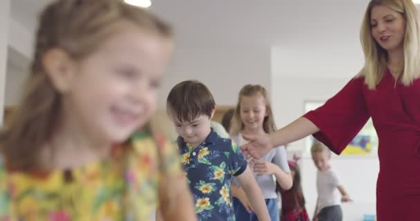 Kleine Kindergartenkinder Mit Einer Lehrerin Auf Dem Fußboden Klassenzimmer Die — Stockvideo