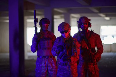 Asker ekibi şehir ortamında resim yapıyor. Renkli neon ışıklar.