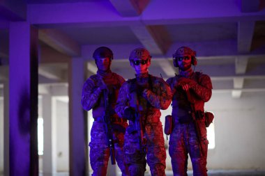 Asker ekibi şehir ortamında resim yapıyor. Renkli neon ışıklar.