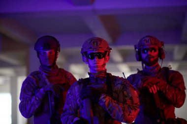 Asker ekibi şehir ortamında resim yapıyor. Renkli neon ışıklar.