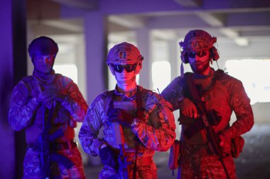 Asker ekibi şehir ortamında resim yapıyor. Renkli neon ışıklar.