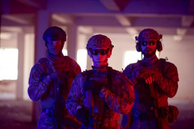 Asker ekibi şehir ortamında resim yapıyor. Renkli neon ışıklar.