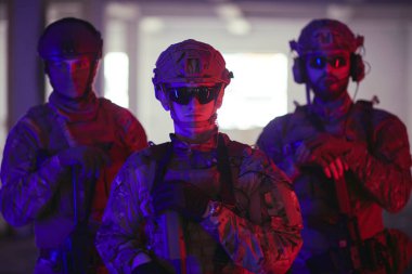 Asker ekibi şehir ortamında resim yapıyor. Renkli neon ışıklar.