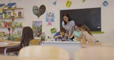 İlköğretim Okulu Bilim Sınıfı: Coşkulu Öğretmen Kimyayı Çeşitli Çocuklar Grubu 'na Açıkladı, Küçük Çocuk Kimyasalları Beakers' a Karıştırdı. Çocuklar Faiziyle Öğrenin