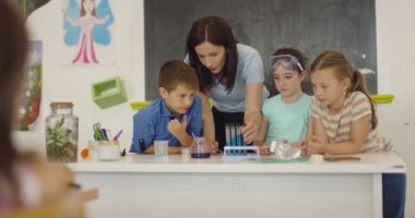 İlköğretim Okulu Bilim Sınıfı: Coşkulu Öğretmen Kimyayı Çeşitli Çocuklar Grubu 'na Açıkladı, Küçük Çocuk Kimyasalları Beakers' a Karıştırdı. Çocuklar Faiziyle Öğrenin