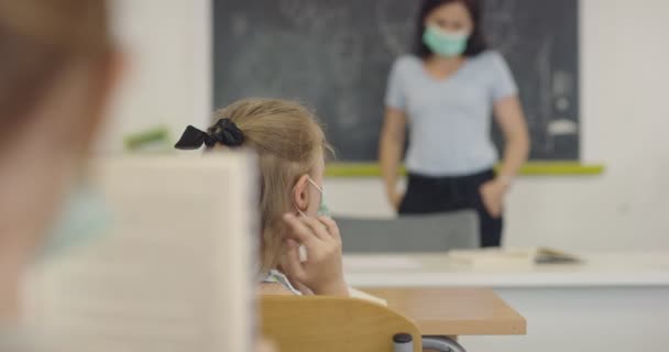 Der Lehrer forderte den Schüler auf, ihm eine Maske aufzusetzen. Unterricht während der Pandemie in der Schule. — Stockvideo