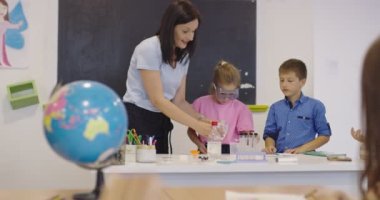 İlköğretim Okulu Bilim Sınıfı: Coşkulu Öğretmen Kimyayı Çeşitli Çocuklar Grubu 'na Açıkladı, Küçük Çocuk Kimyasalları Beakers' a Karıştırdı. Çocuklar Faiziyle Öğrenin