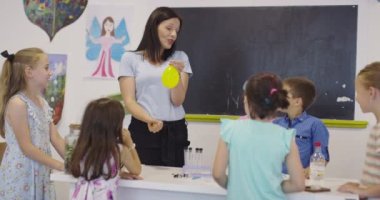 4K, öğrenciler fen dersinde öğretmenlerinin gözetimi altında deney yapıyorlar. Yavaş çekim.