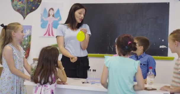 4k, élèves effectuant des expériences en classe de sciences sous les yeux vigilants de leur professeur. Mouvement lent. — Video