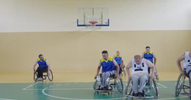 Engelli insanlar modern salonda basketbol oynarlar.