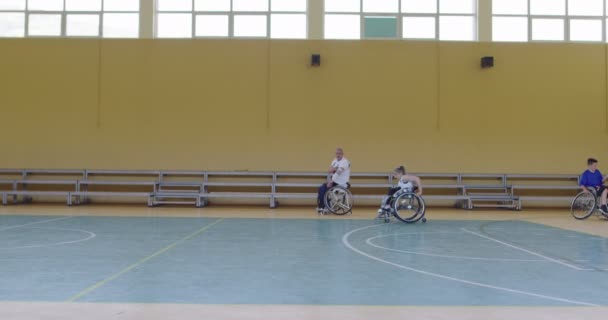 Persons with disabilities preparing for basketball match in the modern hall. Slow motion — 图库视频影像