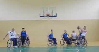 Engelli insanlar modern salonda basketbol oynarlar.