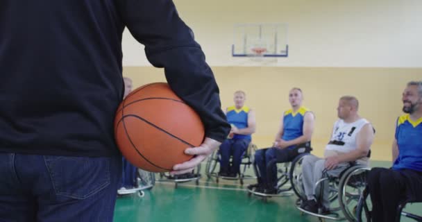 Selettore Spiego nuove tattiche ai giocatori di basket in sedia a rotelle, alle persone con disabilità sedute in sedia a rotelle ascoltando il selettore — Video Stock