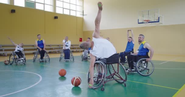 Persons with disabilities stretching before a basketball game in the modern hall. Slow motion — Vídeo de Stock