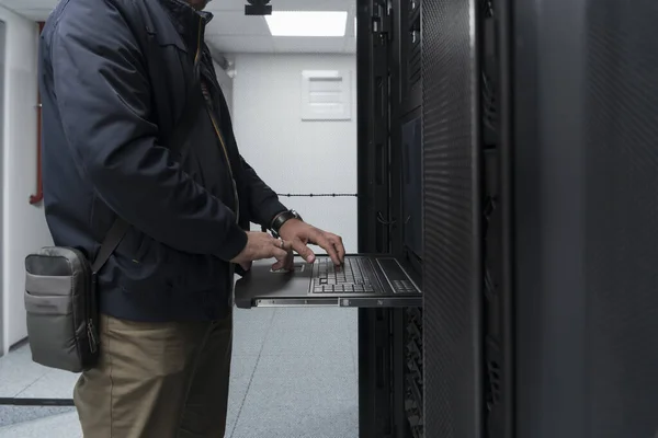 データセンターエンジニアの手で閉じるスーパーコンピュータのキーボードを使用してください 男性システム管理者とのサーバールーム専門施設サイバーセキュリティのためのデータ保護ネットワークの作業 — ストック写真