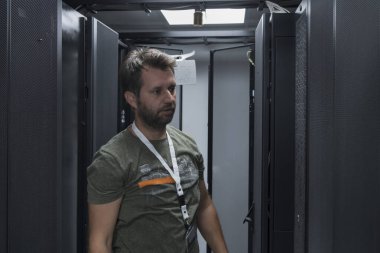 Bilgi işlem mühendisi sunucu odasında ya da veri merkezinde çalışıyor. Teknisyen bir rafa koyarak şirket ana bilgisayarının yeni sunucusunu ya da kripto para birimi çiftliğini kurar.. 
