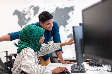 Çok ırklı girişimci Arap kadın takımı modern açık planlı ofis iç mimarisinde buluşmaya tesettüre girmiş, dizüstü bilgisayar ve bilgisayar üzerinde çalışıyor. Seçici odaklanma. Yüksek kalite