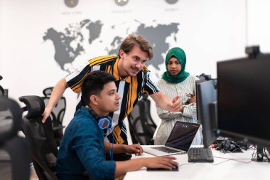 Çok ırklı girişimci Arap kadın takımı modern açık planlı ofis iç mimarisinde buluşmaya tesettüre girmiş, dizüstü bilgisayar ve bilgisayar üzerinde çalışıyor. Seçici odaklanma. Yüksek kalite
