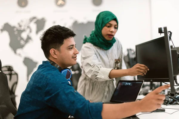 多族裔创业团队阿拉伯女性带着头巾在现代开放计划办公室的内部集思广益 在笔记本电脑和台式计算机上工作 有选择的重点 高质量 — 图库照片