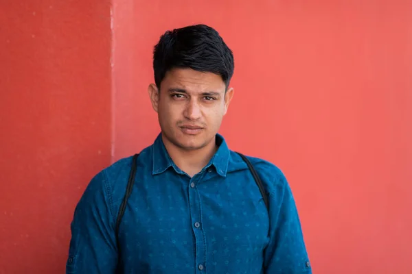 Kırmızı Duvarın Önünde Mavi Gömlekli Sırt Çantalı Sıradan Bir Adamı — Stok fotoğraf