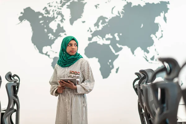 具有绿色头巾的穆斯林女性软件开发人员站在现代开放式计划启动办公室时手持平板电脑的肖像 高质量的照片 — 图库照片