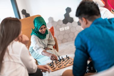 Modern başlangıç ofisinde rahatlama alanında mola verirken aynı zamanda satranç oynayan çok ırklı bir iş adamı grubu. Yüksek kaliteli fotoğraf.