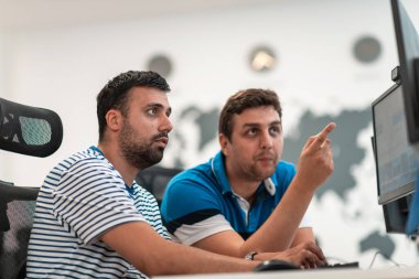 Gündelik iş adamı grubu, modern açık planlı ofis içi masaüstü bilgisayarı üzerinde çalışıyor. Seçici odak 