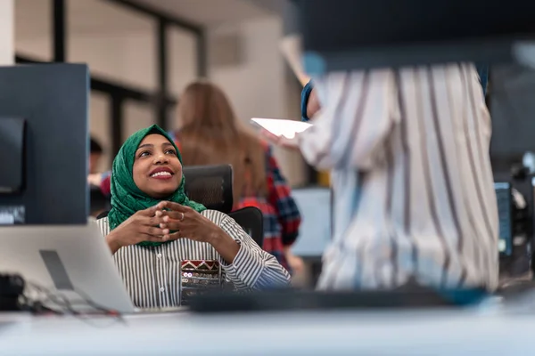 Çok ırklı girişimci Arap kadın takımı modern açık planlı ofis iç mimarisinde buluşmaya tesettüre girmiş, dizüstü bilgisayar ve bilgisayar üzerinde çalışıyor. Seçici odak — Stok fotoğraf