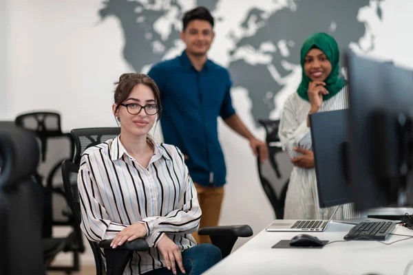 Πολυεθνική γυναίκα startup business team φορώντας χιτζάμπ κατά τη συνάντηση στο σύγχρονο open plan office interior brainstorming, που εργάζονται σε φορητό υπολογιστή και επιτραπέζιο υπολογιστή. Επιλεκτική εστίαση — Φωτογραφία Αρχείου