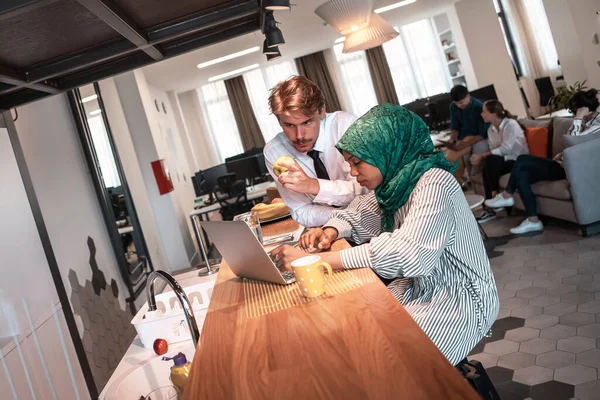 Équipe d'affaires multiculturelle internationale.Un jeune homme et une jeune femme d'affaires s'assoient dans un espace de détente moderne et parlent d'une nouvelle entreprise. — Photo