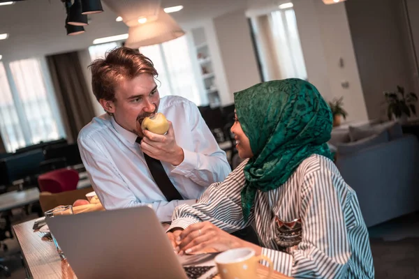 Équipe d'affaires multiculturelle internationale.Un jeune homme et une jeune femme d'affaires s'assoient dans un espace de détente moderne et parlent d'une nouvelle entreprise. — Photo
