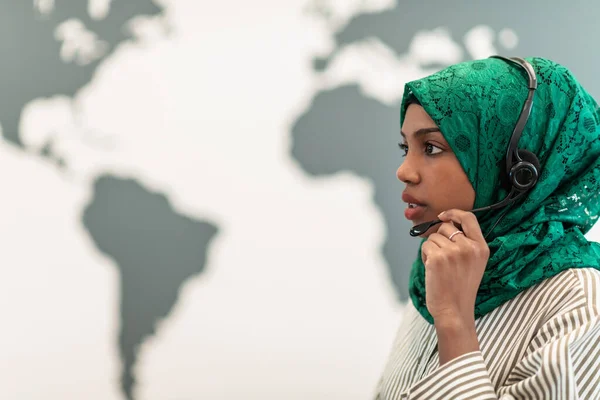 Afro Muslim fêmea com hijab verde cachecol representante do cliente mulher de negócios com fone de ouvido de telefone ajudando e apoiando on-line com o cliente no moderno call center — Fotografia de Stock