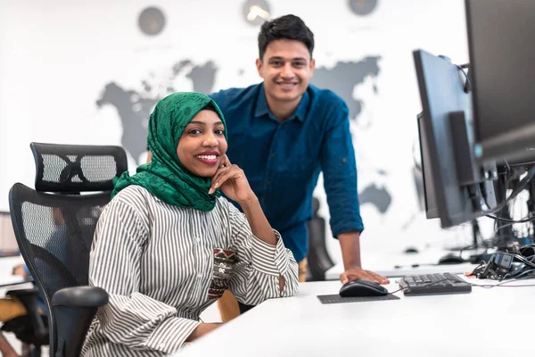 Πολυεθνική γυναίκα startup business team φορώντας χιτζάμπ κατά τη συνάντηση στο σύγχρονο open plan office interior brainstorming, που εργάζονται σε φορητό υπολογιστή και επιτραπέζιο υπολογιστή. Επιλεκτική εστίαση — Φωτογραφία Αρχείου