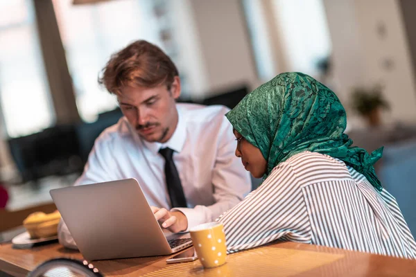 Internationellt mångkulturellt företagsteam.Man och muslim kvinna med hijab arbetar tillsammans med hjälp av smartphone och laptop coxation område på modern öppen planlösning start officemputer i rela — Stockfoto