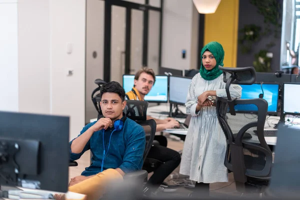 Equipo de negocios de startups multiétnicas Mujer árabe con un hijab en la reunión en la moderna oficina de planta abierta lluvia de ideas interior, trabajando en el ordenador portátil y de escritorio. Enfoque selectivo —  Fotos de Stock