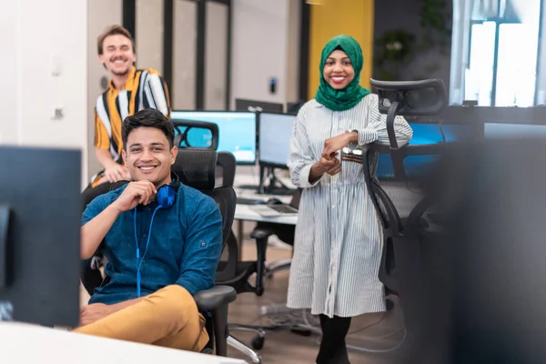 Multiethnique start-up business team femme portant un hijab sur la réunion dans moderne open plan bureau intérieur remue-méninges, travailler sur ordinateur portable et ordinateur de bureau. Concentration sélective — Photo