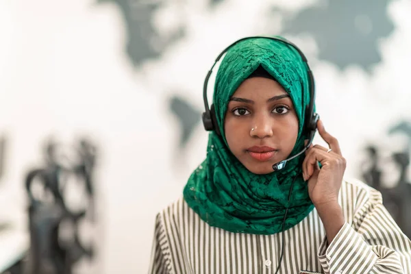 Mulher muçulmana com lenço hijab verde representante do cliente mulher de negócios com fone de ouvido de telefone ajudando e apoiando on-line com o cliente no moderno call center — Fotografia de Stock