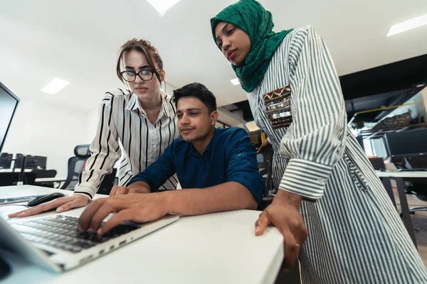 Multietnico avvio business team donna indossa un hijab sulla riunione in moderno open space ufficio brainstorming interno, lavorando su computer portatile e desktop. Focus selettivo — Foto Stock