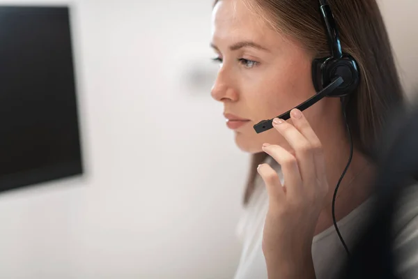 Opérateur de ligne d'assistance avec écouteurs dans le centre d'appel.Femme d'affaires avec écouteurs travaillant dans un centre d'appel. Concentration sélective — Photo