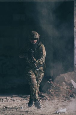 Tehlikeli bir düşman bölgesinde tehlikeli bir askeri harekat sırasında özel kuvvetler üniforması içinde sakallı bir asker. Seçici odaklanma. Yüksek kaliteli fotoğraf.