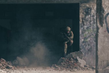 Tehlikeli bir düşman bölgesinde tehlikeli bir askeri harekat sırasında özel kuvvetler üniforması içinde sakallı bir asker. Seçici odaklanma. Yüksek kaliteli fotoğraf.