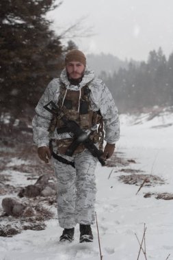 Çağdaş savaş ordusunda kışın kamufle olmuş bir asker. Orman savaş meydanında bir tüfekle. Model, Ukrayna başbakanına çok benziyor. Yüksek kalite fotoğraf. 