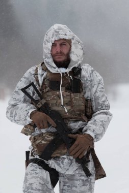 Çağdaş savaş ordusunda kışın kamufle olmuş bir asker. Orman savaş meydanında bir tüfekle. Model, Ukrayna başbakanına çok benziyor. Yüksek kalite fotoğraf. 