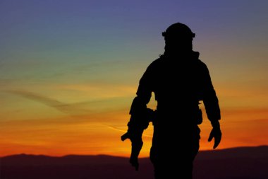Piyade askerlerinin silueti, deniz piyadeleri savaşçısı, donanma özel harekat timinin tam teçhizatlı üyesi helikopterlerle birlikte havadan indirme operasyonu sırasında ellerinde silahla koşuyor.