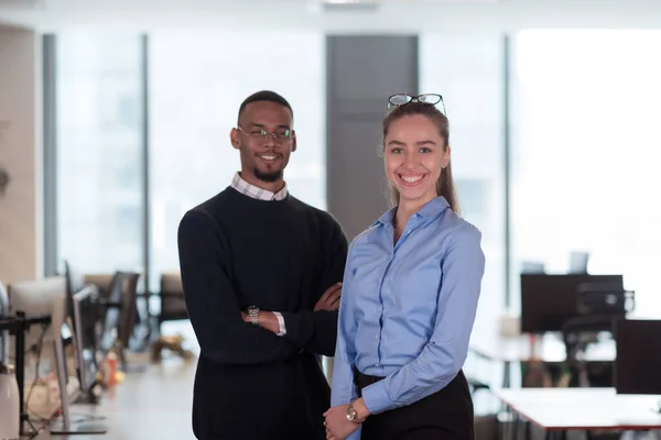 Twee gelukkige diverse professionele executive business team mensen vrouw en Afro-Amerikaanse man kijken naar de camera staan in de hal van het kantoor. Teamportret van multiculturele bedrijfsleiders. — Stockfoto